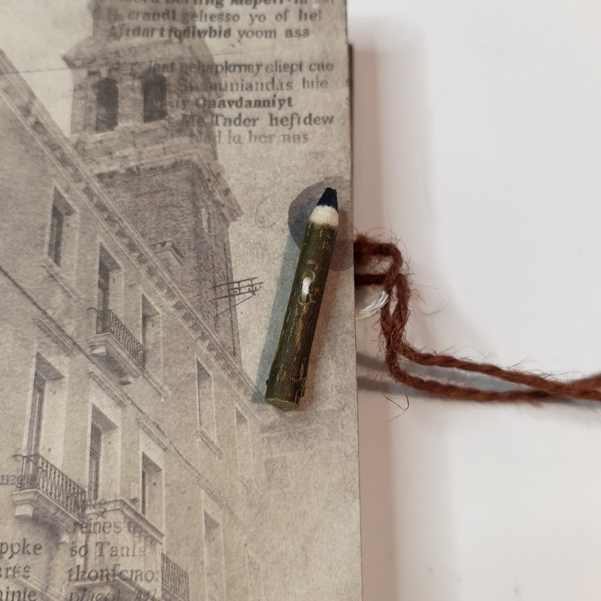 Dettaglio della chiusura con bottone a forma di matitina in legno